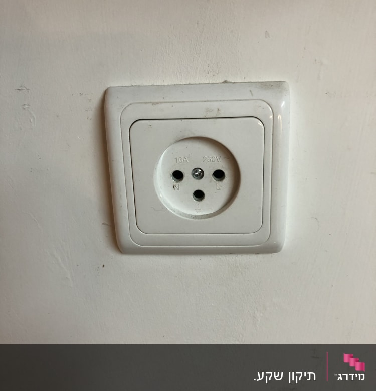 שקע חשמל לבן בקיר עם שלושה חורים